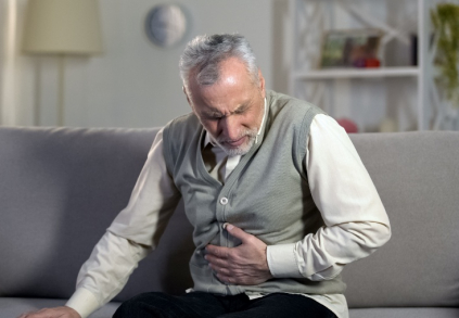 ileus neboli střevní neprůchodnost muž se drží za břicho kvůli bolesti