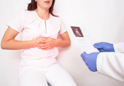lékař drží výsledek sono a pacient se drží za břicho kvůli nemoci familiární adenomatózní polypózy
